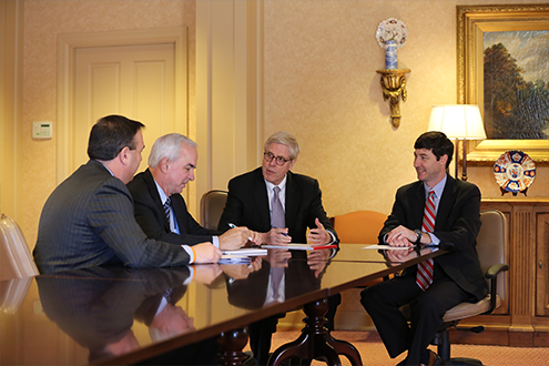 four men sitting at a conference table